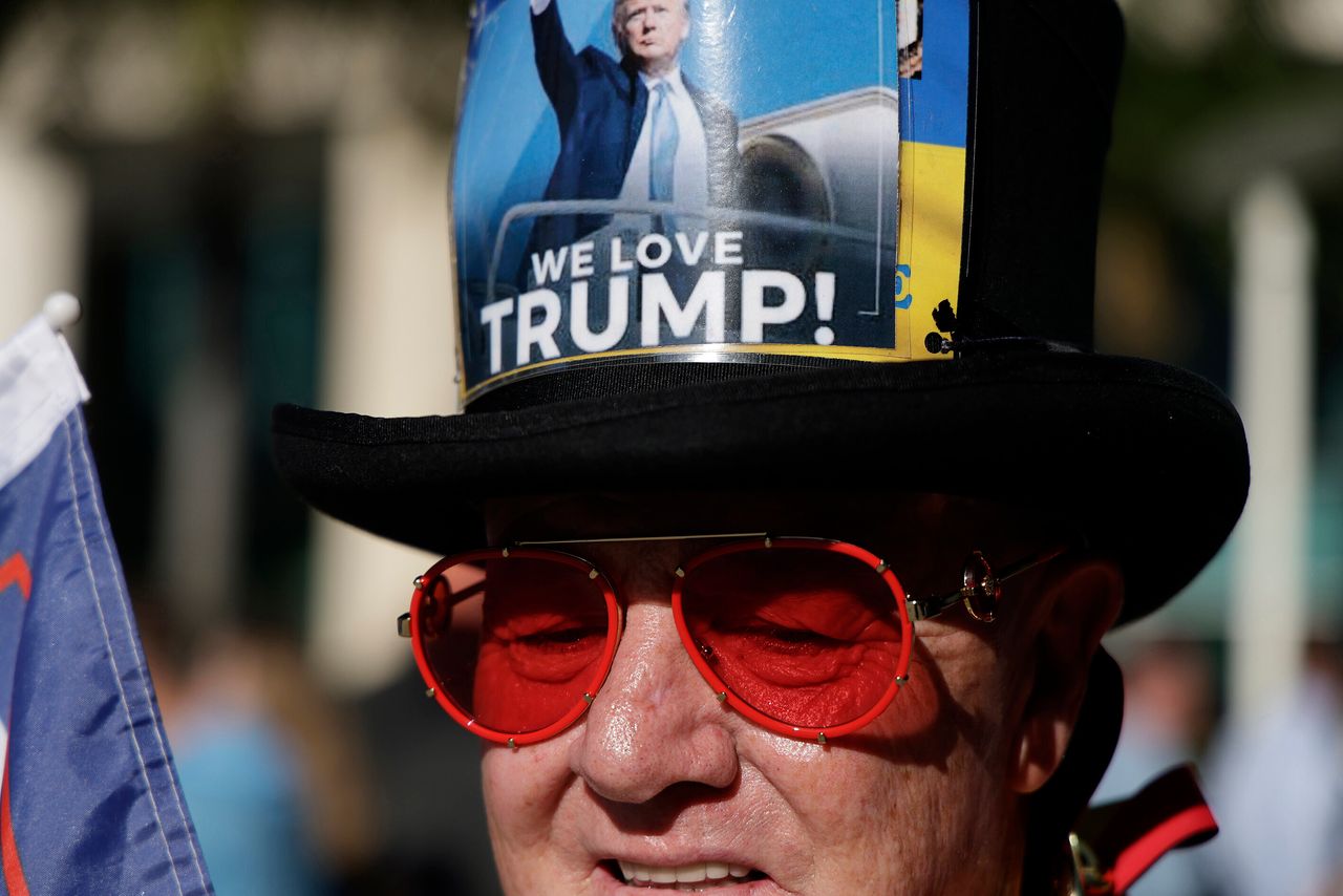 Gregg Donovan waits outside the Miami courthouse, wearing a hat that reads "We Love Trump!"