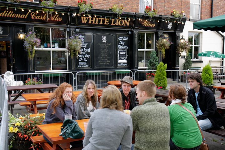 Students drinking ale outside the White Lion Pub in Manchester. 