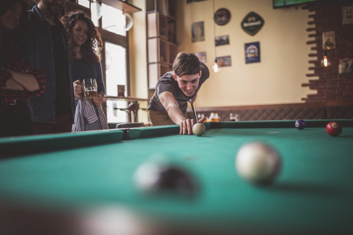 Group of friends playing pool in the pub