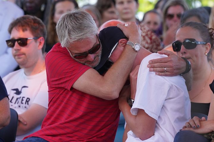 The family of Barnaby Webber – father David (left) and brother Charlie – embrace during a vigil at the University of Nottingham.
