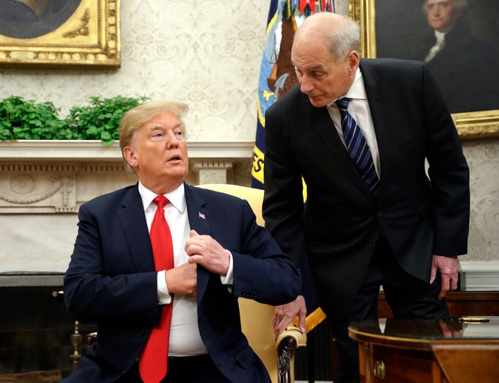 White House chief of staff John Kelly leans in to talk with President Donald Trump during a meeting with Portuguese President Marcelo Rebelo de Sousa in the Oval Office on June 27, 2018.