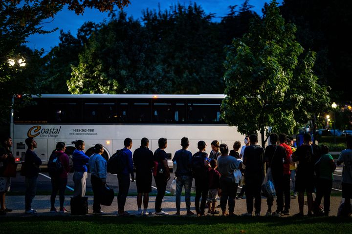 Migrants who were sent on a bus from Texas line a sidewalk near the U.S. Capitol on Aug. 11, 2022.