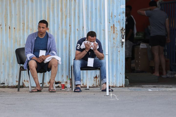 Mετανάστες, μετά την ανατροπή του σκάφους τους, κάθονται έξω από μια αποθήκη που χρησιμοποιείται ως καταφύγιο, στο λιμάνι της Καλαμάτας, Ελλάδα, 15 Ιουνίου 2023. REUTERS/Stelios Misinas