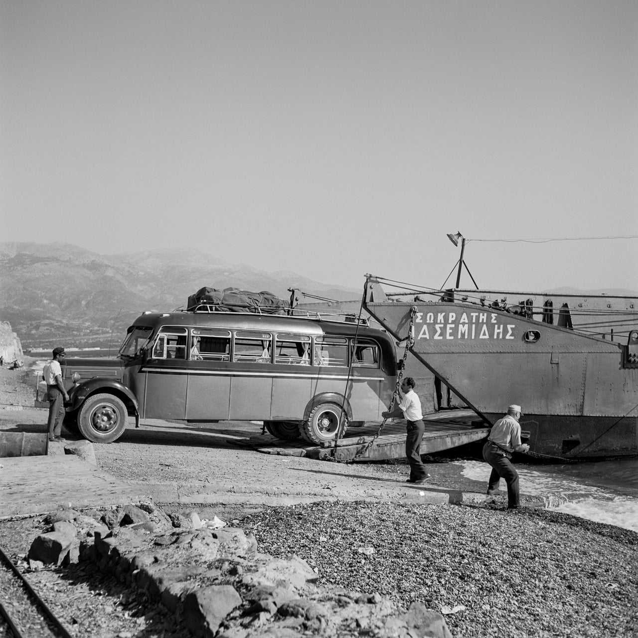 Το πορθμείο Ρίου-Αντιρρίου το 1955. Τώρα έχει αντικατασταθεί από μια κομψή γέφυρα γαλλικού σχεδιασμού. Το σύντομο ταξίδι στον Κορινθιακό Κόλπο ήταν πάντα περιπετειώδες. Το ίδιο το φεριμπότ ήταν ένα επαναχρησιμοποιημένο αποβατικό πλοίο από τον πόλεμο. Το πλοίο «Σωκράτης Ιασεμίδης» ήταν ένα από τα πρώτα αποβατικά πλοία βρετανικής κατασκευής και ήταν ένα από τα δύο LST που κατέστρεψαν οι βρετανικές δυνάμεις κατά την αποχώρησή τους από την Ελλάδα τον Απρίλιο του 1941.