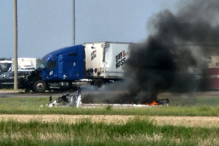 Smoke comes out of a car following a road accident that left 15 dead near Carberry, west of Winnipeg, Canada on June 15, 2023. (Photo by Nirmesh VADERA / AFP)