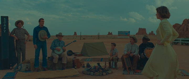 Rupert Friend (second from right) stands among cowboys played by Pere Mallen, Jean-Yves Lozac'h, Jarvis Cocker and Seu Jorge as he looks on at Maya Hawke, who plays teacher June Douglas in Wes Anderson's latest film "Asteroid City."