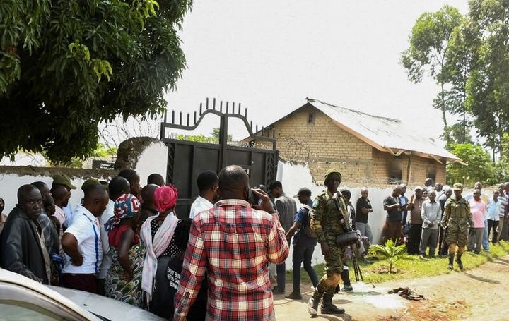 Οι δυνάμεις ασφαλείας της Ουγκάντα φρουρούν το σχοελίο, καθώς οι ντόπιοι συγκεντρώνονται 'εξω από το λύκειο Μποντούε-Λουμπιρίχα.