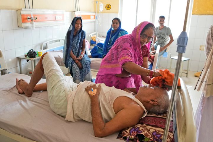 Η Shiela Mishra σκουπίζει το κεφάλι του άρρωστου αδελφού της για να τον κρατήσει δροσερό από το κύμα καύσωνα χρησιμοποιώντας ένα υγρό πανί στο περιφερειακό νοσοκομείο στην Ballia, στο κρατίδιο Uttar Pradesh, Ινδία, Δευτέρα 19 Ιουνίου 2023.