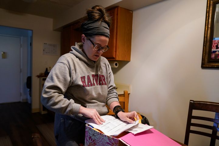 Samantha Richards looks over her Medicaid papers, Friday, June 9, 2023, in Bloomington, Ind. Richards has been on Medicaid her whole life and currently works two part-time jobs as a custodian. (AP Photo/Darron Cummings)
