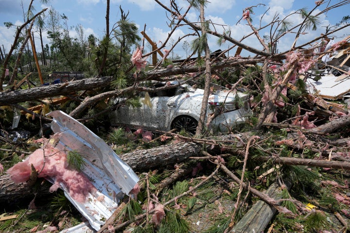 A sedan is buried in debris of a Sunday night tornado that swept through the small community of Louin, Miss., Monday, June 19, 2023. (AP Photo/Rogelio V. Solis)