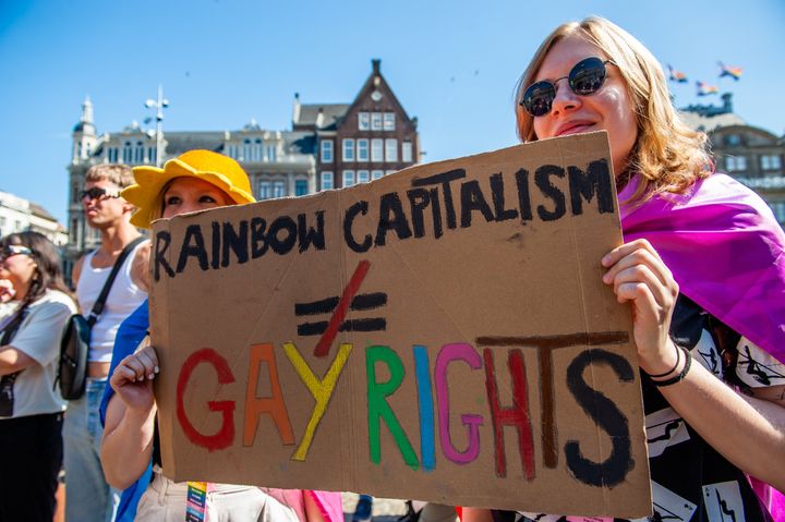 Two women are seen holding a placard against capitalism during an annual equal rights demonstration for the global rainbow community took place in Amsterdam last year. Under the motto 'Be who you are, love who you want', Pride Amsterdam wants the acceptance and equality of LGBTI people around the world.