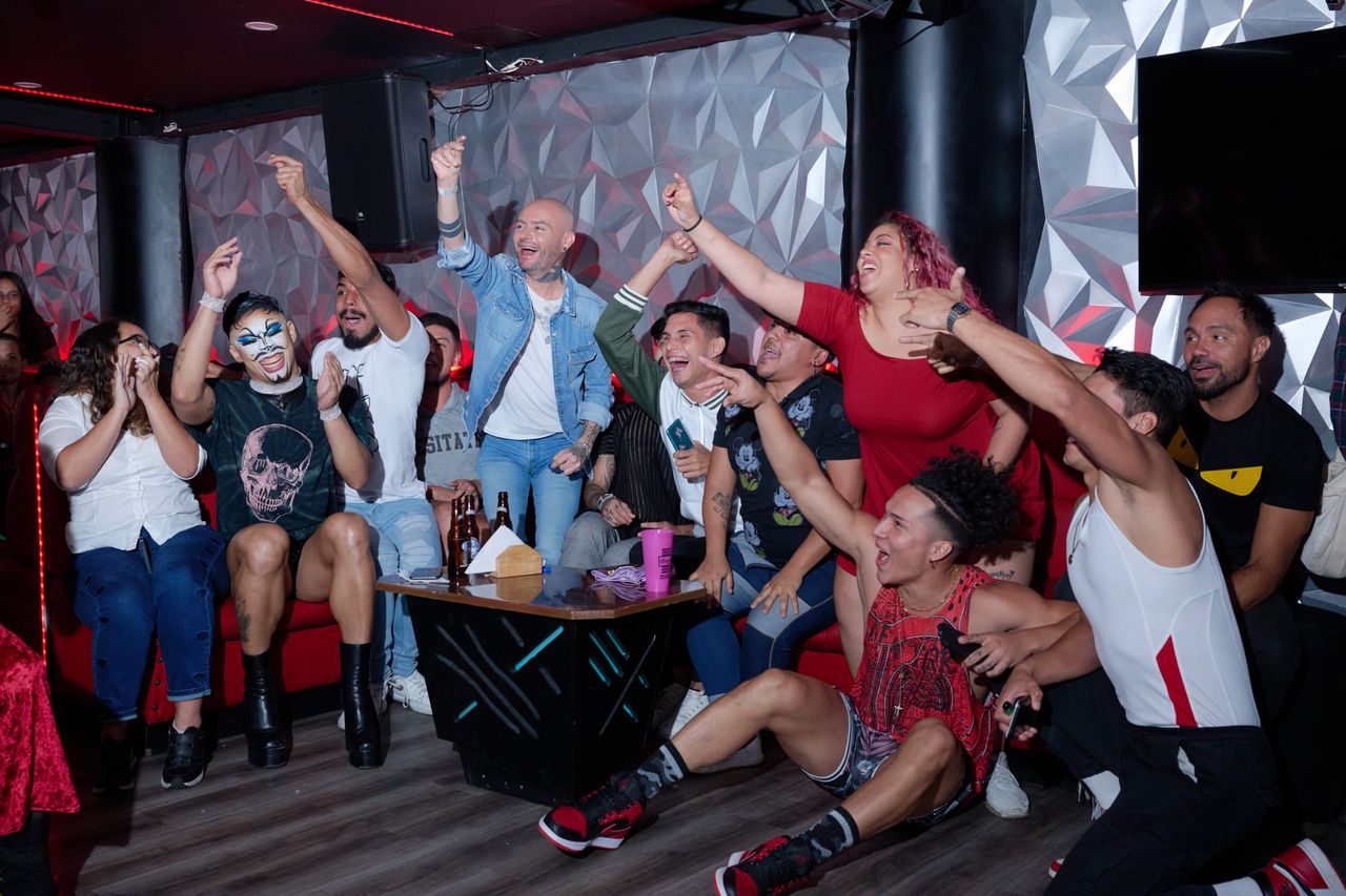 Personas de la comunidad drag, trans y vogue animan a los artistas en un baile organizado en un club queer en el centro de Caracas.