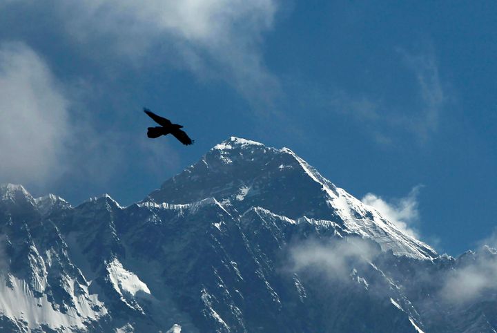 FILE - A bird flies with Mount Everest seen in the background from Namche Bajar, Solukhumbu district, Nepal, May 27, 2019. A new report Tuesday, June 20, 2023, from a Nepal-based research organization finds that water security for nearly 2 billion people living downstream of rivers that originate in the Himalayan ranges will likely be threatened by the end of this century due to rapid glacier melt if global warming is not controlled. (AP Photo/Niranjan Shrestha, File)