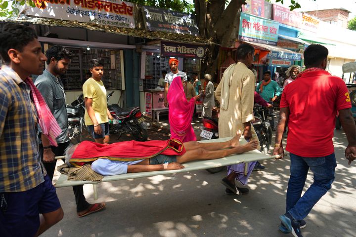 Un anciano que sufre de una dolencia relacionada con el calor es llevado en camilla al hospital del distrito del gobierno en Ballia, estado de Uttar Pradesh, India, el lunes 19 de junio de 2023.