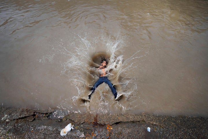 A boy jumps into a canal on a hot day in Jammu, India, Tuesday, June 20, 2023. Many parts of India are experiencing scorching heat this summer. (AP Photo/Channi Anand)