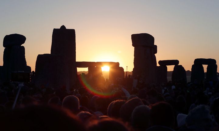 The sun rises as thousands of revelers gather at the ancient stone circle Stonehenge to celebrate the Summer Solstice in 2019.