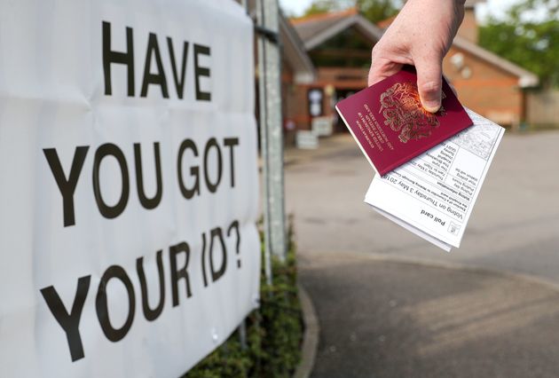 A voter carrying his passport along with his poll card, as he makes his way to vote at The Vyne polling station in Knaphill.