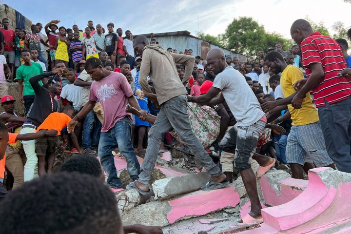 Άνθρωποι κουβαλούν τραυματιμσένο άντρα ύστερα από κατάρρευση σπιτιού, εξιατίας του σεισμού που σημειώθηκε σε κοινότητα της Αϊτής την Τρίτη 6 Ιουνίου 2023.