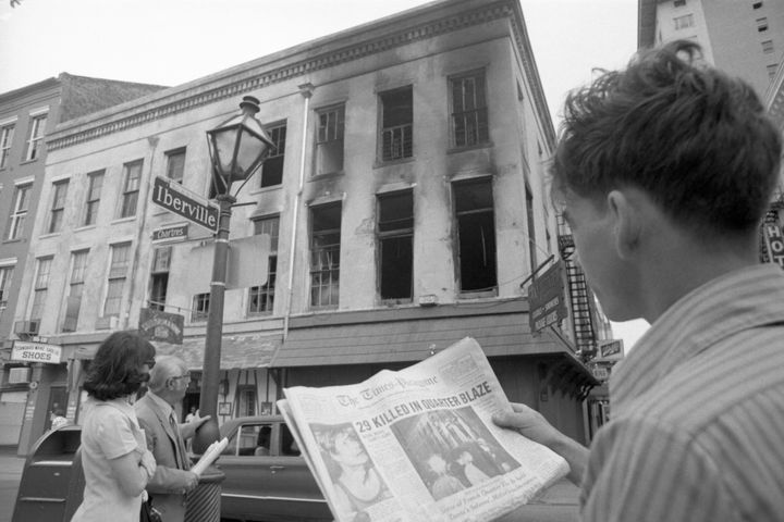 On his way to work on June 25, Chris Benitez glances from the headline in his morning paper to the gutted building in the French Quarter where 32 people died the previous night in a fire in an upstairs bar.