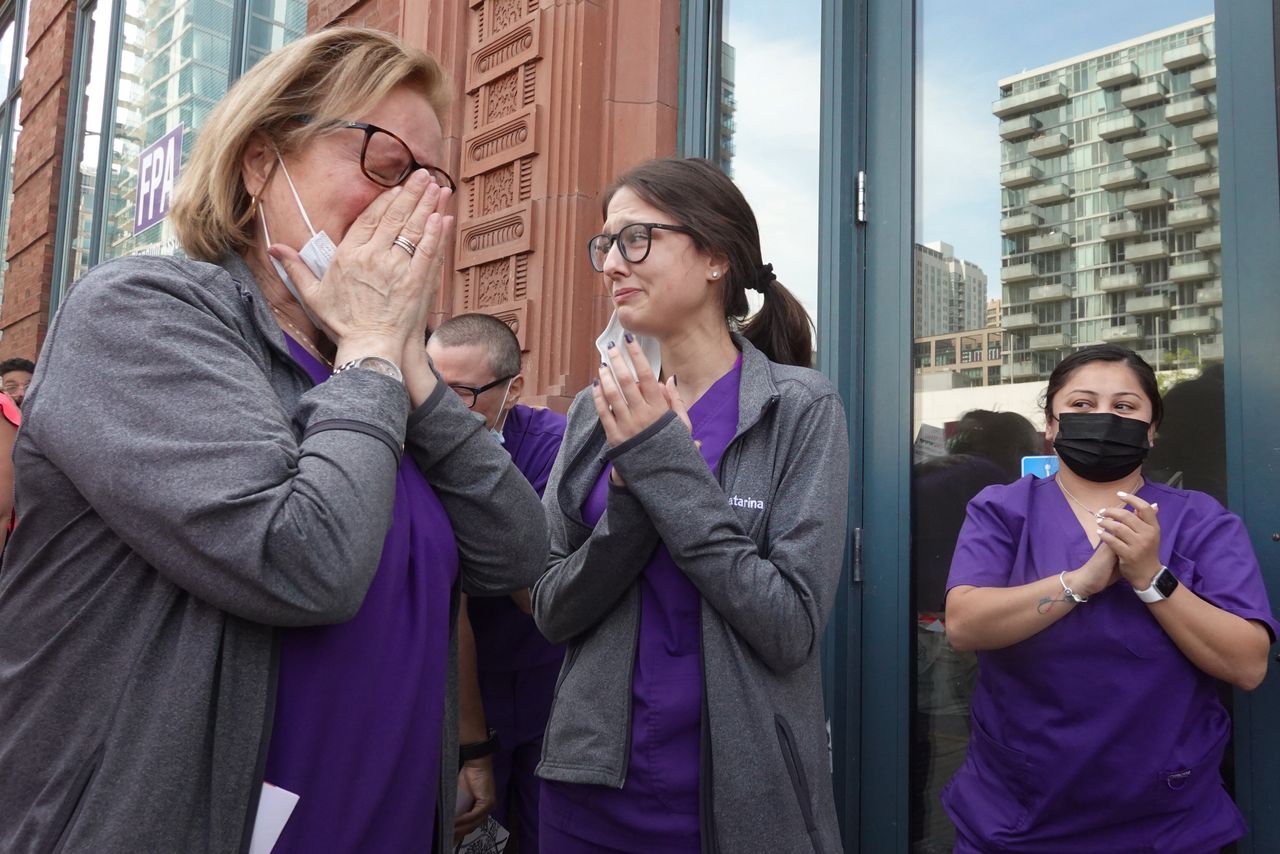 Workers at a family planning clinic in Chicago get emotional as thousands of abortion rights demonstrators march past their clinic chanting their support.
