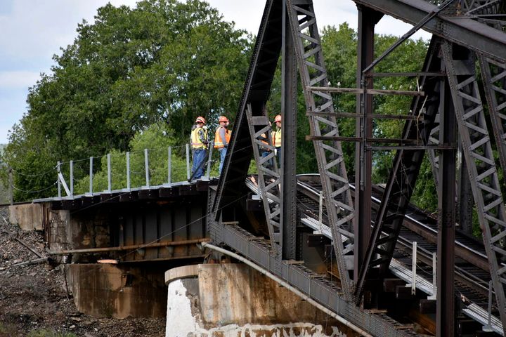 Emergency crews respond to the scene where several train cars are immersed in the Yellowstone River after a bridge collapse near Columbus, Mont., on Saturday, June 24, 2023. The bridge collapsed overnight, causing a train that was traveling over it to plunge into the water below. (AP Photo/Matthew Brown)