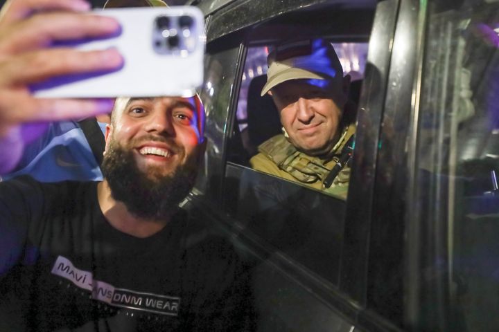 Yevgeny Prigozhin, the owner of the Wagner Group military company, right, sits inside a military vehicle posing for a selfie photo with a local civilian on a street in Rostov-on-Don, Russia, on June 24, 2023, prior to leaving an area of the headquarters of the Southern Military District.