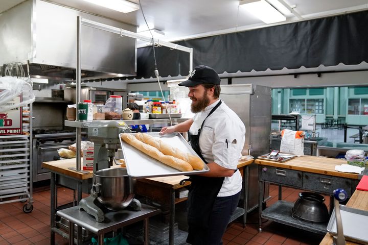 Chef Josh Gjersand puts two baguettes in the oven before making a salami sandwich for students at Mount Diablo High School during a taste test in Concord, California on January 13.