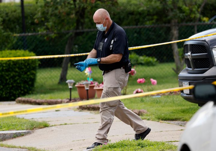An investigator walks out of a home along Broadway Street, Sunday, June 25, 2023, in Newton, Mass.