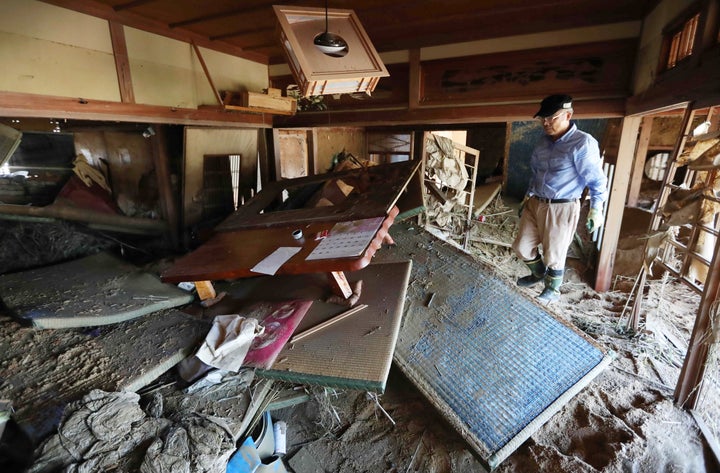 浸水で激しい被害のあった地域で自宅の片付けをする住民の男性＝2018年7月9日、岡山県倉敷市