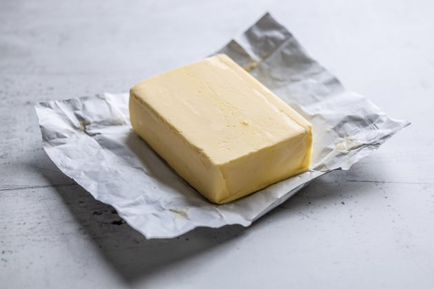 Whole butter unwrapped and placed on the table - Close - up.