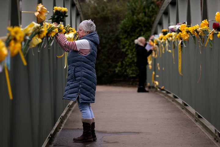 Women attach flowers to a footbridge over the River Wyre in tribute to Nicola Bulley in St Michael's on Wyre on February 21, 2023 in Preston, England.
