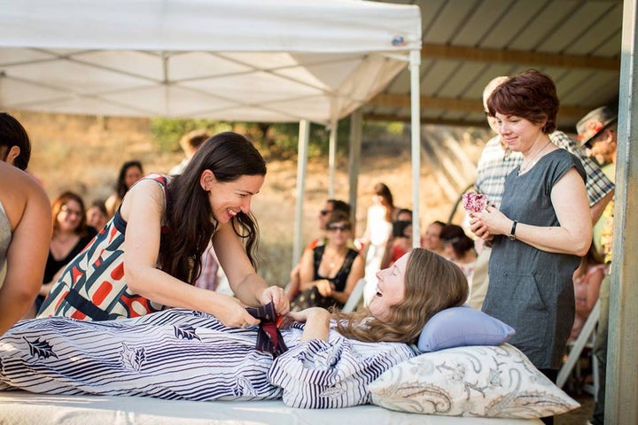 Journalist Kelly Davis said her late sister, Betsy, wanted to get her friends and family together for a "rebirth" gathering the weekend she ended her life. Here, Davis watches as a friend fixes a bow on Betsy's dress at the event. 