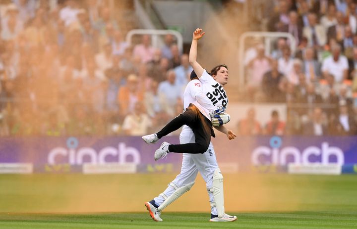 Jonny Bairstow of England removes a "Just Stop Oil" pitch invader during Day One of the LV= Insurance Ashes 2nd Test match between England and Australia at Lord's Cricket Ground on Wednesday.