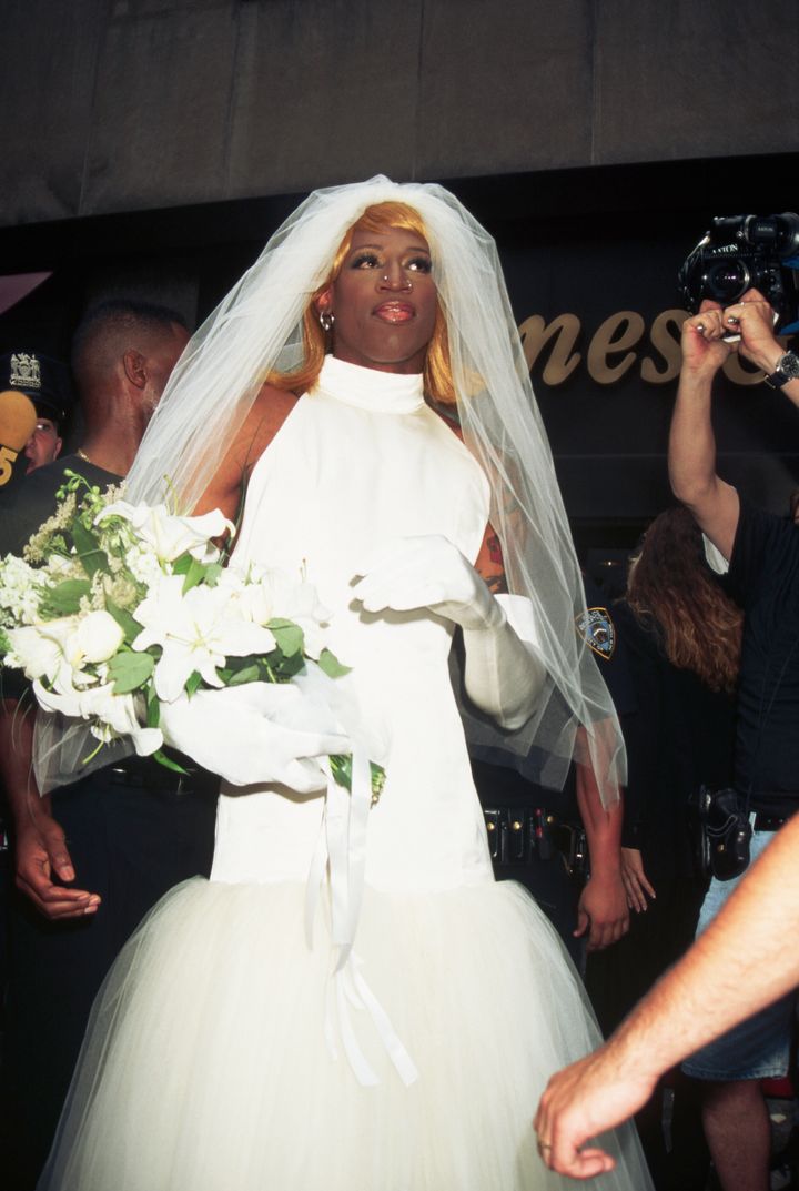 Dennis Rodman, dressed as a bride, is surrounded by photographers in Rockefeller Center.