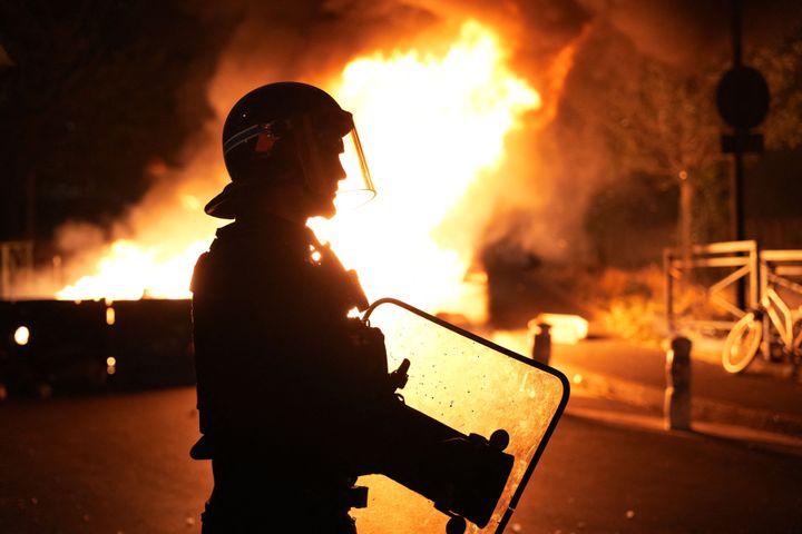 A firefighter looks on as vehicles burn following riots in Nanterre, west of Paris, on June 28, 2023, following the death of 17-year-old Nahel.