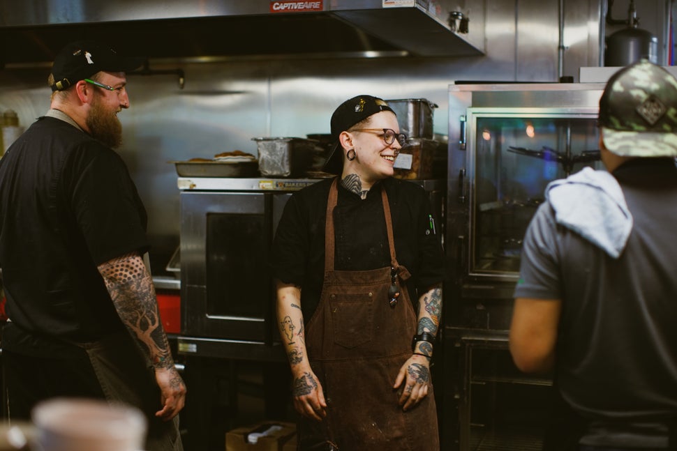 Renton Sinclair and Graham Fox Farris chat with co-workers in the kitchen.