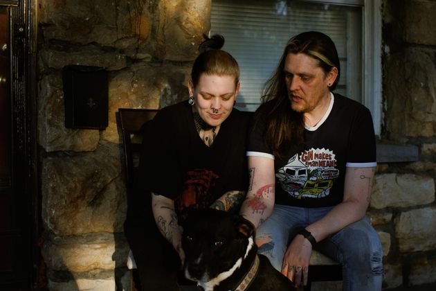 Renton Sinclair and his partner Greg Hyatt pet one of their dogs, Tiberias, on their porch in Kansas City.