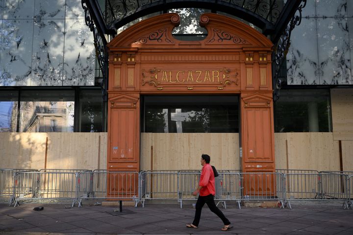 2023年6月30日、フランス南部のマルセイユにあるアルカザール図書館の前を歩く歩行者。入り口が暴徒たちによって破壊され、木製のパネルで覆われている。（Photo by NICOLAS TUCAT/AFP via Getty Images）