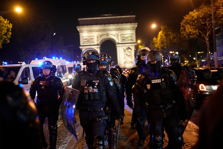 Police officers patrol in front of the Arc de Triomphe on the Champs Elysees in Paris, on July 1, 2023. 