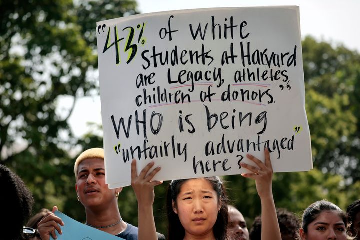アファーマティブ・アクションを違憲とした最高裁判所の判決に抗議するハーバード大学の学生。手にしたプラカードには「43%の白人の生徒はレガシー入学、アスリート、寄付者の子ども。不当に優位なのは誰なのか？」と書かれている