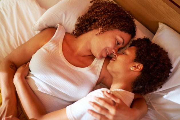 Affectionate couple laying in bed.