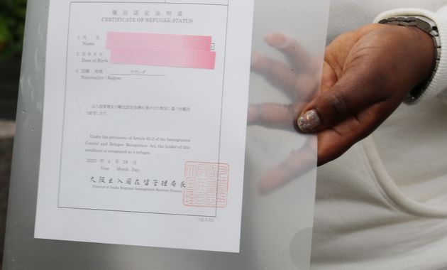 難民認定証明書を手にするウガンダ国籍の女性＝2023年4月、大阪市内