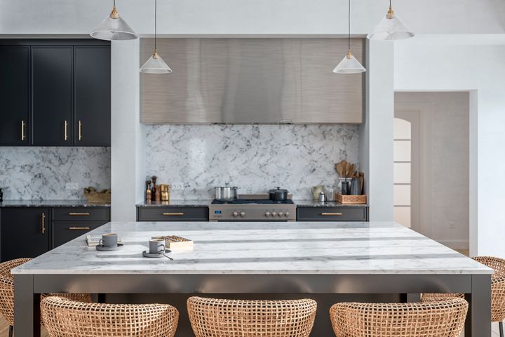 Modern kitchen with white walls and marble countertops. 