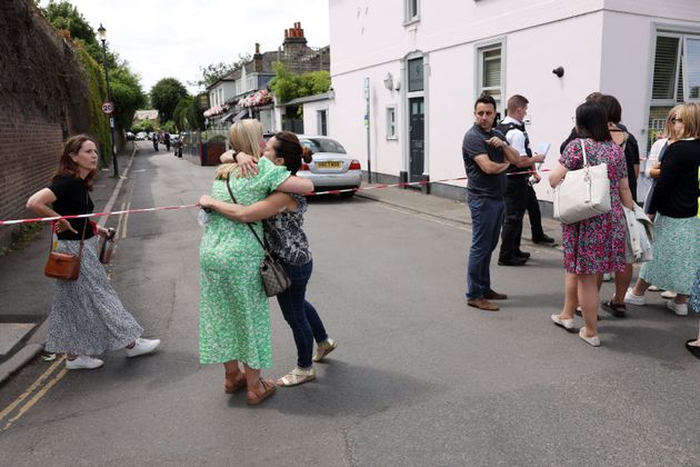 People gather outside a cordon at the scene of the car crash.