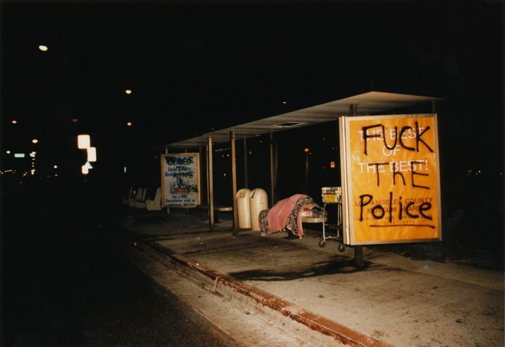 Um aimed to deepen her understanding of Black history and the stereotypical way Korean Americans have been portrayed in American films like "Do the Right Thing," particularly in the aftermath of the Los Angeles uprising, while crafting a nuanced conversation about anti-Blackness in her own community. Pictured: An unhoused person sleeps at a bus stop in Los Angeles with graffiti stating "Fuck the Police" and referencing Rodney King and Latasha Harlins.