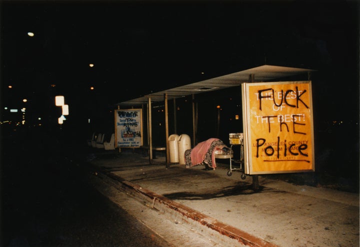 Um aimed to deepen her understanding of Black history and the stereotypical way Korean Americans have been portrayed in American films like "Do the Right Thing," particularly in the aftermath of the Los Angeles uprising, while crafting a nuanced conversation about anti-Blackness in her own community. Pictured: An unhoused person sleeps at a bus stop in Los Angeles with graffiti stating "Fuck the Police" and referencing Rodney King and Latasha Harlins.