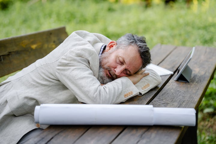 Tired senior businessman taking a break from work in nature