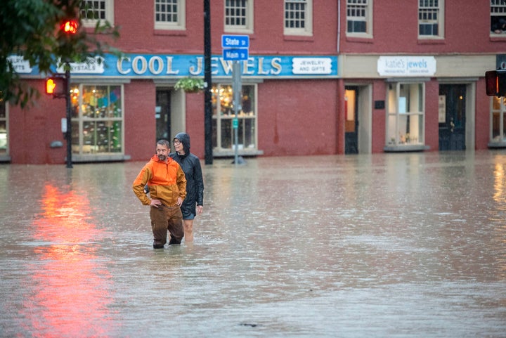 Montpelier resident Ben Cheney and a companion survey rising floodwaters at the intersection of State and Main streets in downtown Montpelier, Vermontt., on Monday night, July 10, 2023.