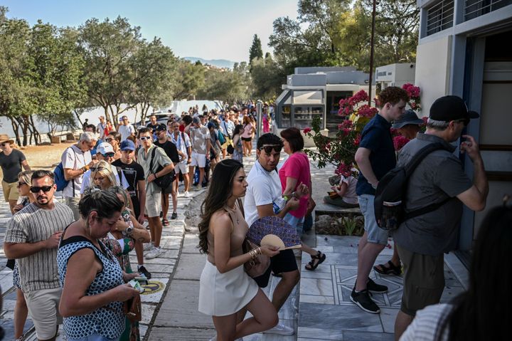 14 Ιουλίου 2023, Ελλάδα, Αθήνα: Οι τουρίστες περιμένουν σε μεγάλη ουρά για τα εισιτήριά τους για τον ναό του Παρθενώνα στον λόφο της Ακρόπολης αυτή τη ζεστή μέρα. Το Υπουργείο Πολιτισμού αποφάσισε να κλείσει τον αρχαιολογικό χώρο τις πιο ζεστές ώρες της ημέρας, από το μεσημέρι έως τις 5 το απόγευμα, καθώς αυτή την περίοδο η Ελλάδα βιώνει κύμα καύσωνα.