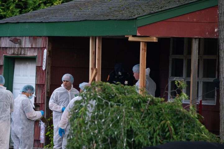Investigators, some in protective suits, searched the suspect's home Friday.